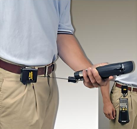 Man met Gear Keeper retractor aan een riemclip met uitgetrokken lijn waaraan een handscanner voor in het magazijn of warehouse bevestigd zit