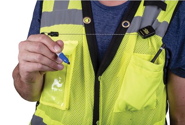Gear Keeper RT5-5605 retractor aan een veiligheidsvest met een pen vastgehouden in de hand
