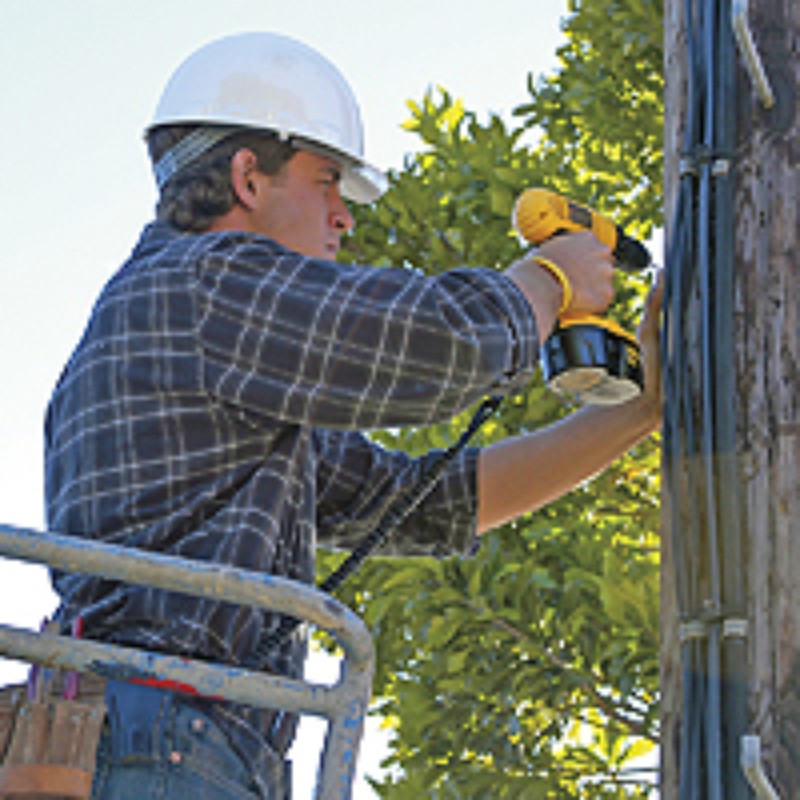 Bouwvakker die met een accu boormachine werkt die gezekerd is aan een Gear Keeper personal tooltether